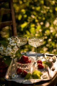 A celebratory toast with two glasses of sparkling wine and one red wine against a backdrop of majestic mountains and lush vineyards. Raise your glasses to memorable moments and picturesque vistas. #CelebrationToast #MountainVineyardView #WineCountry