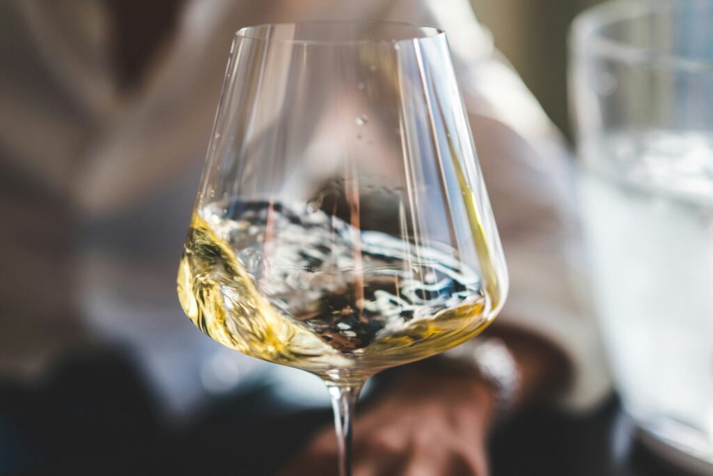 Swirling white wine in a glass during a wine tasting session - Enhancing aroma and flavor experience