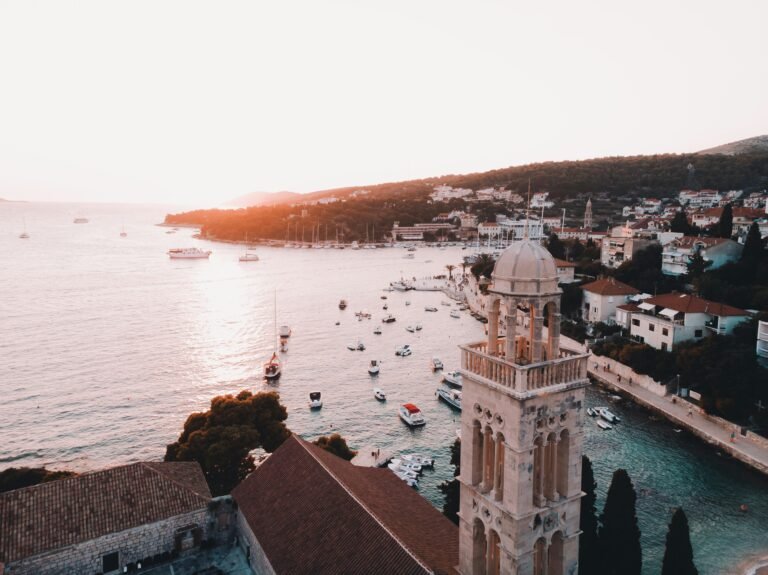 Panoramic view of Hvar, Croatia, featuring the tranquil sea and a picturesque church perched atop the hill, beckoning travelers to explore its timeless beauty