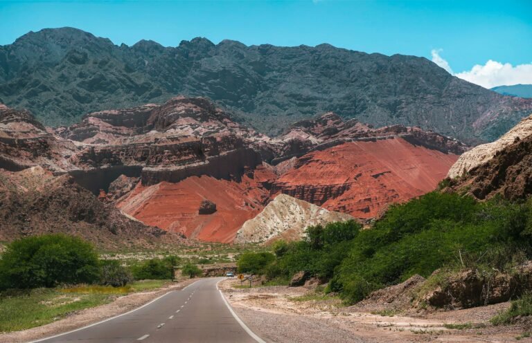 Scenic view of red mountains against blue sky along a road in Salta, Argentina.