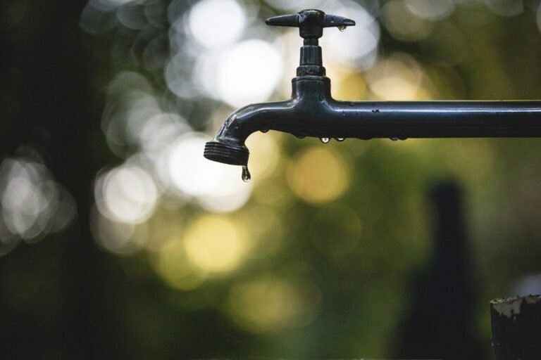 Water Conservation: Close-up of a faucet with a single water drop, highlighting the importance of water-saving practices.