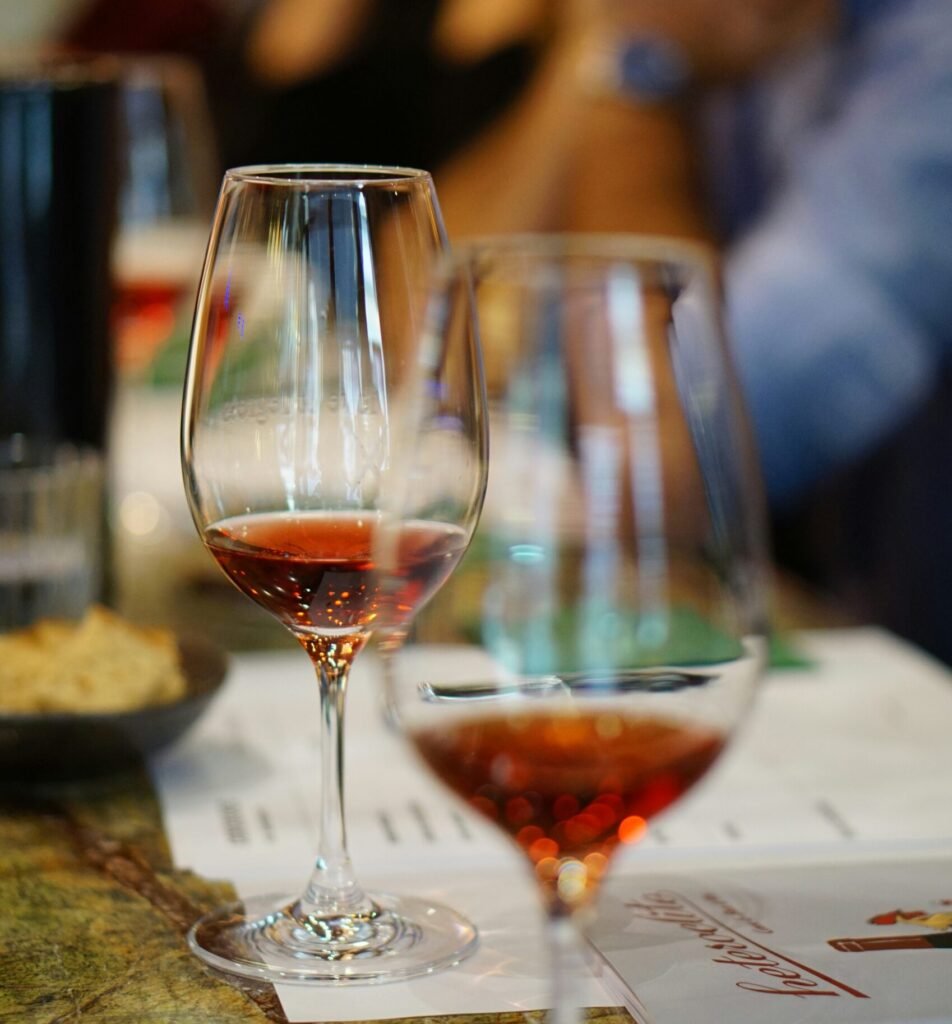 Two glasses of vibrant orange wine elegantly served on a dining table, showcasing the rich color and allure of this trendy beverage.