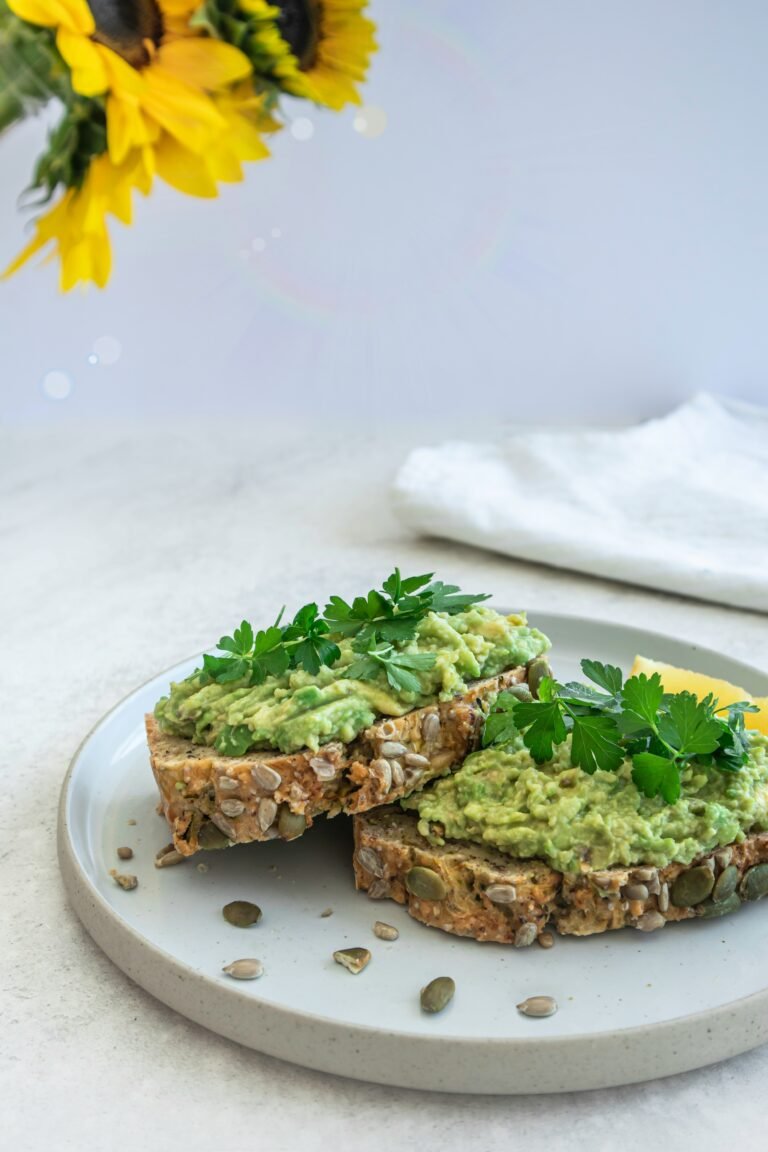 Enjoy a vibrant avocado toast topped with ripe avocado slices, a nutritious and trendy breakfast choice packed with healthy fats and flavor.