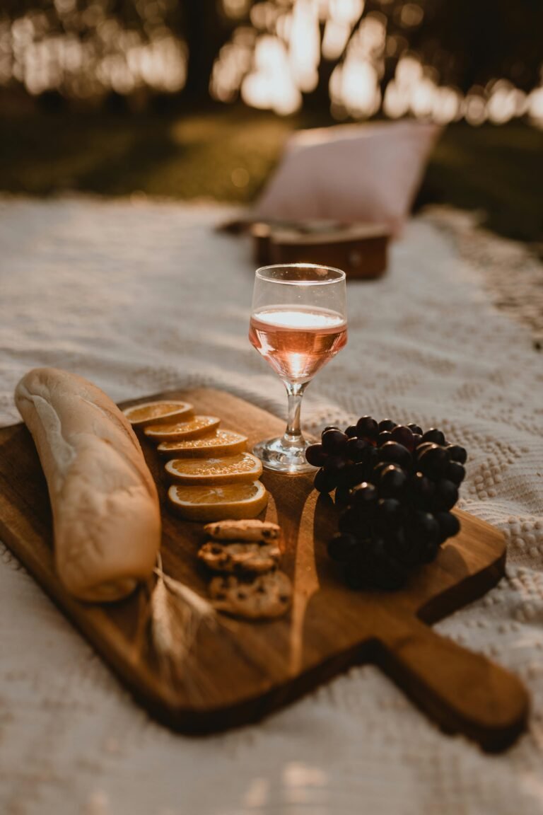 A glass of refreshing orange wine nestled in a picnic setting, offering a perfect blend of relaxation and indulgence.