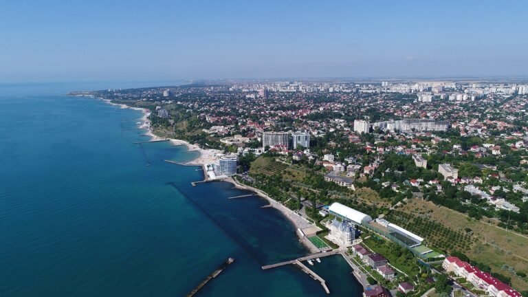 Aerial view of the Black Sea coastline with city buildings and clear blue water.