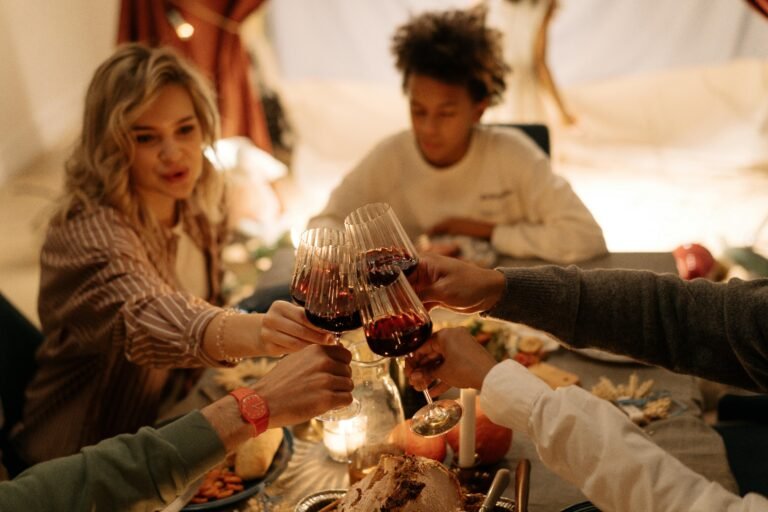 Friends toasting with glasses of red wine at a festive dinner table