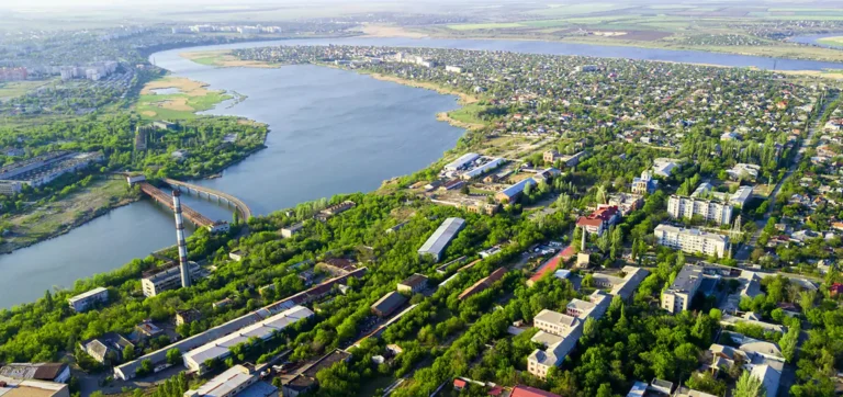 Aerial view of Nikolaev city with lush greenery and a river running through it.