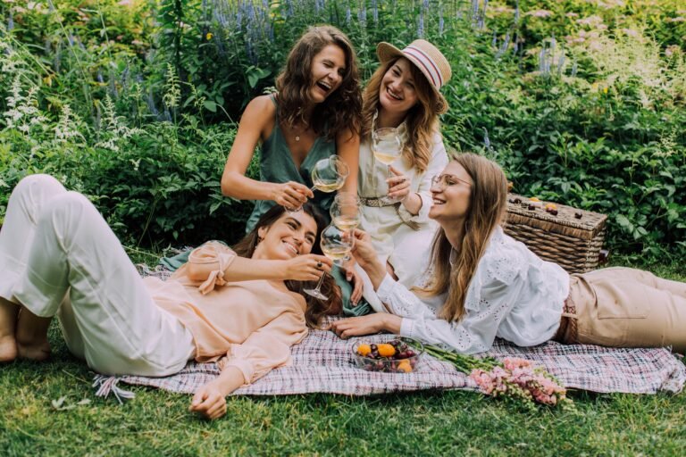 Group of friends enjoying a picnic with wine in a garden