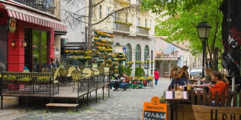 Charming street scene in Skadarlija, Belgrade with outdoor café seating, colorful flowers, and historic buildings