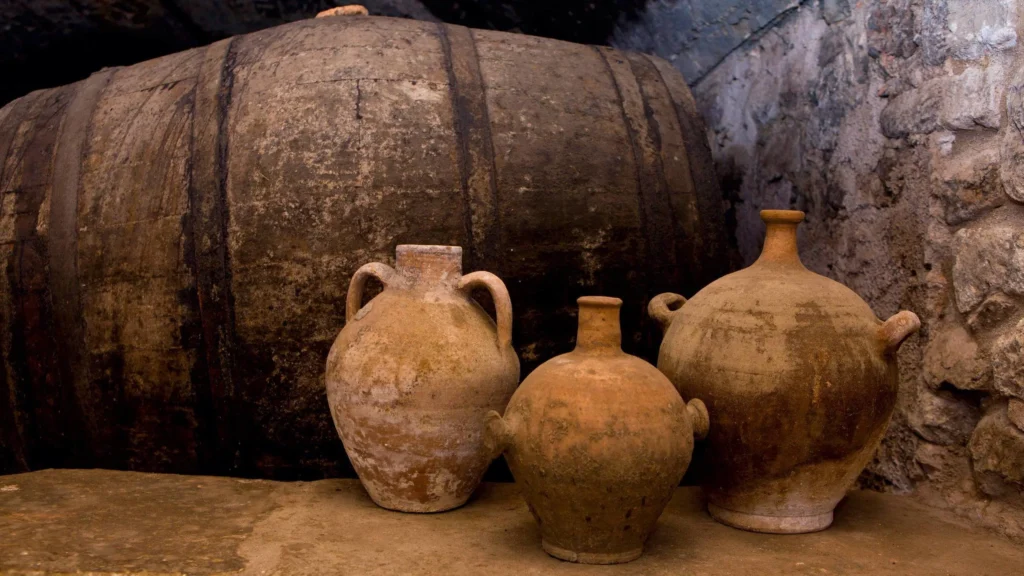 Ancient wine barrels and pottery in a cellar.