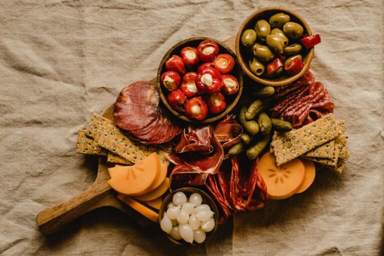 Cheese board featuring an assortment of cheeses and prosciutto as the main highlight