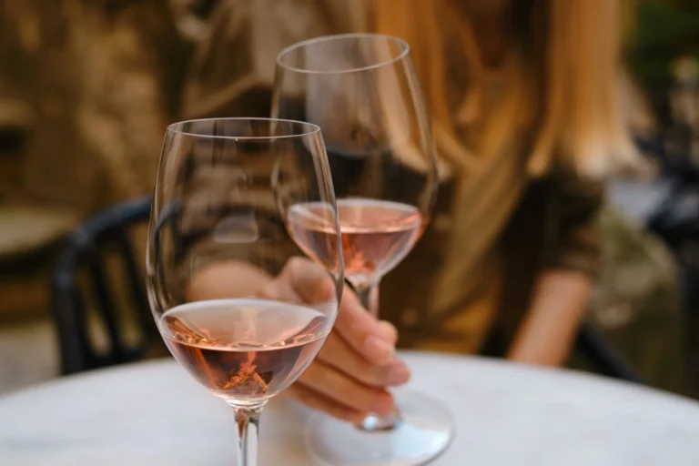 Two glasses of rosé wine clinking together, capturing a moment of celebration and enjoyment.