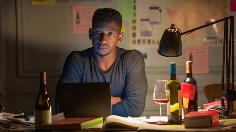 The protagonist of the movie Uncorked reflecting on the day while sitting in front of a laptop with a glass of wine.