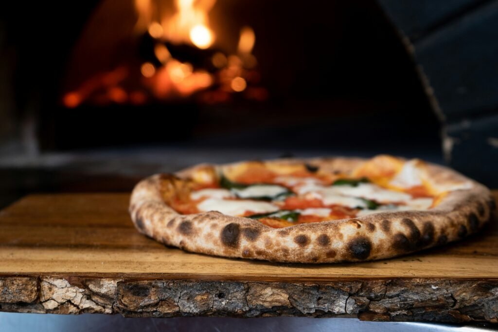 Margherita pizza fresh out of a stone oven with melted mozzarella and fresh basil