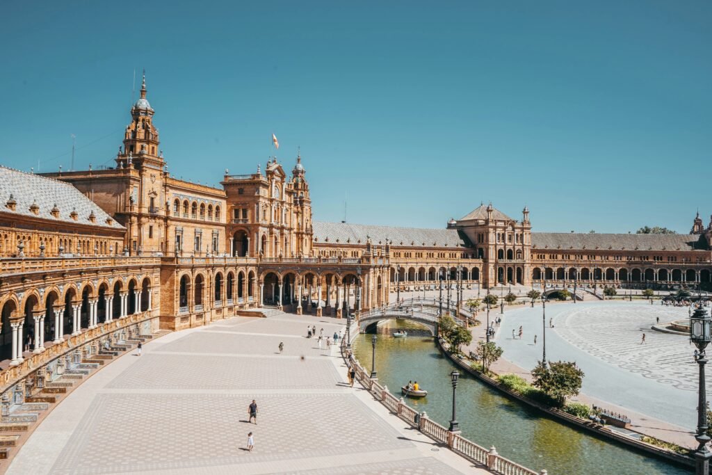 Plaza España in Seville, a sunlit square with a canal.