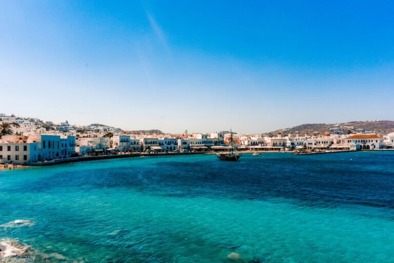 Scenic view of Mykonos, Greece with white buildings and a deep blue sea.