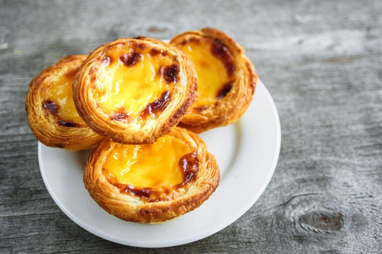 A plate of freshly baked Pastéis de Nata, traditional Portuguese custard tarts.