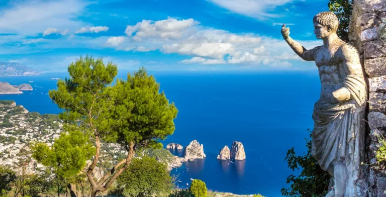 Stunning view of the coast of Naples, Italy, with clear blue waters and rocky formations.