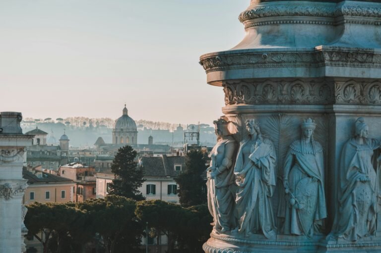 Scenic view of Rome with intricate statues in the foreground and cityscape in the background.