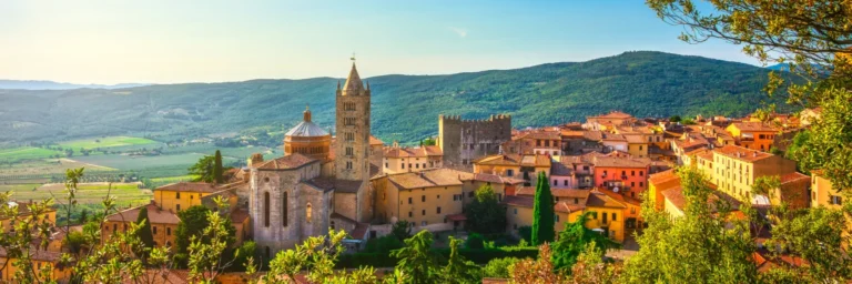 Scenic view of the charming town of Tuscany, Italy, surrounded by lush green hills.