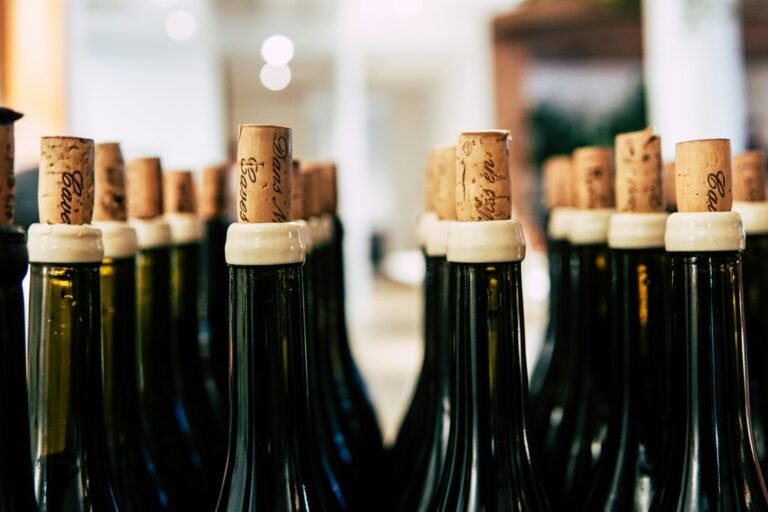 Rows of corked wine bottles in a cellar with soft, blurred background lighting.