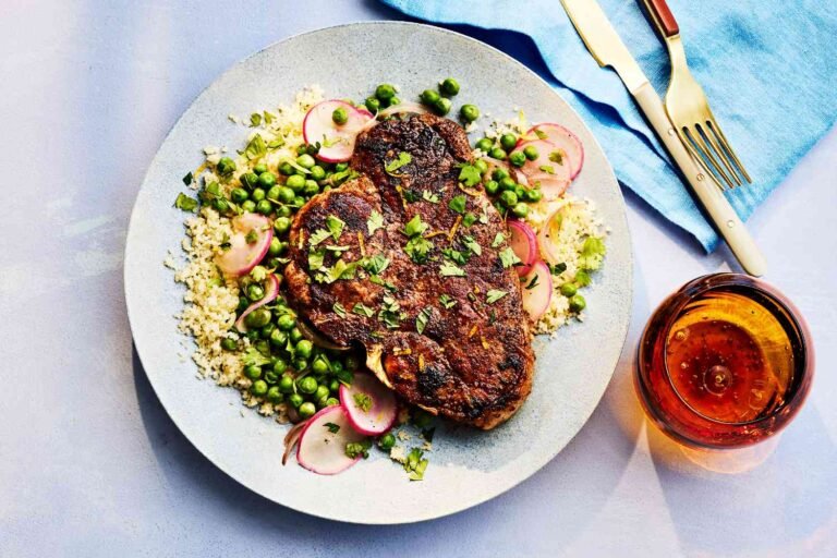 Grilled steak served with couscous, peas, and radishes on a modern plate.