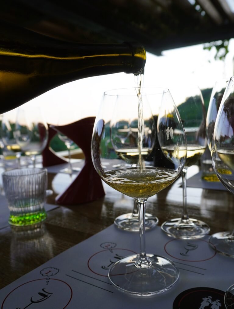 A close-up of golden Malvazija Istarska wine being elegantly poured into a wine glass, capturing the essence of Istria's renowned white wine, known for its fresh, aromatic flavours and perfect food pairings.