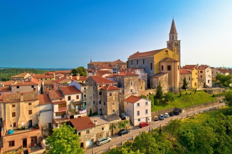 A panoramic view of an ancient Istrian town with its church tower, terracotta roofs, and historic stone buildings.