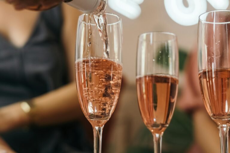 Pouring rosé champagne into glasses during a celebration