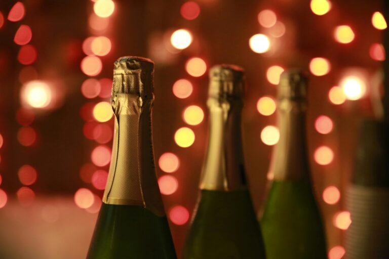 Close-up of champagne bottles with festive lights in the background