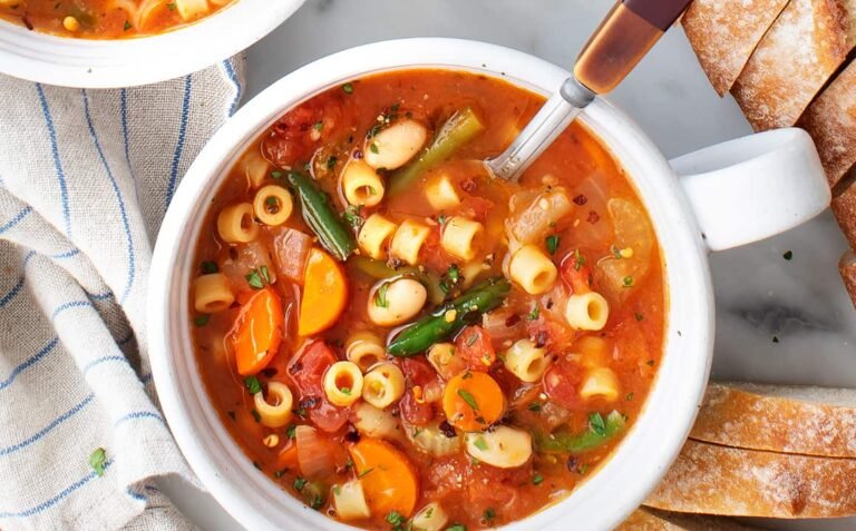 Hearty vegetable minestrone soup in a white bowl