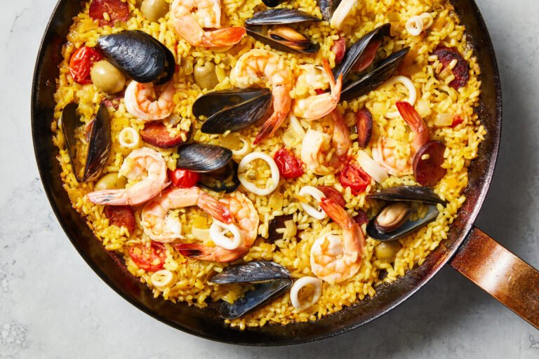 Traditional Spanish seafood paella with shrimp, mussels, and calamari served in a pan.