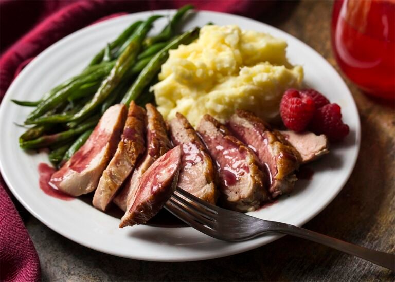 Tender duck breast slices topped with raspberry sauce, served with green beans and mashed potatoes.