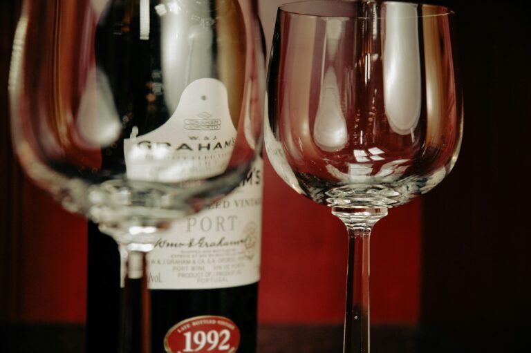 Close-up of a vintage Port wine bottle with empty glasses, ready for a tasting experience.