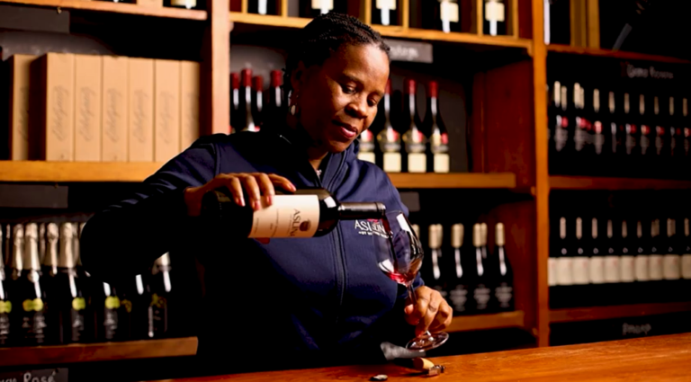 Ntsiki Biyela, renowned South African winemaker, pouring red wine at Aslina Wines tasting room.