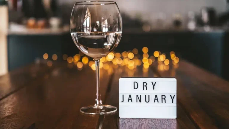 Dry January concept with a calendar, a glass of water, and tips for an alcohol-free month.