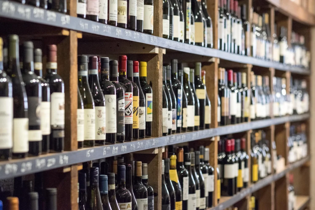 Shelves filled with assorted wine bottles in a wine shop, showcasing different labels and varieties.