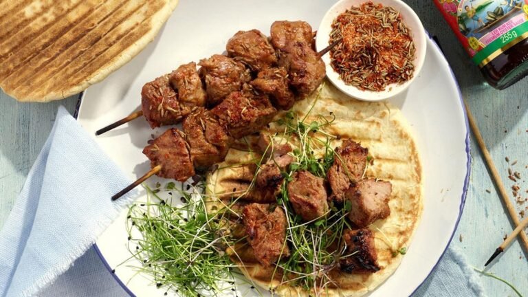 Grilled Chinese lamb skewers served on flatbread with microgreens and spices on a rustic plate.