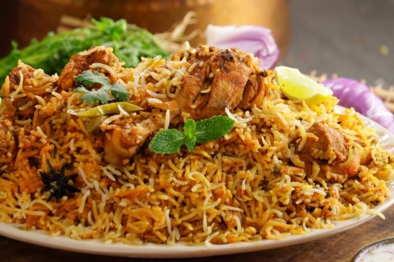 Authentic Indian chicken biryani with basmati rice, spices, and herbs served with lemon and mint garnish.