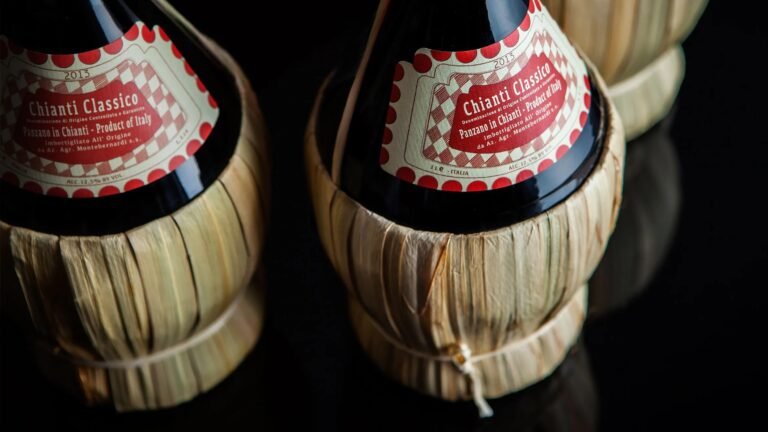 Close-up of traditional Chianti Classico wine bottles wrapped in straw baskets, produced in Panzano in Chianti, Italy.
